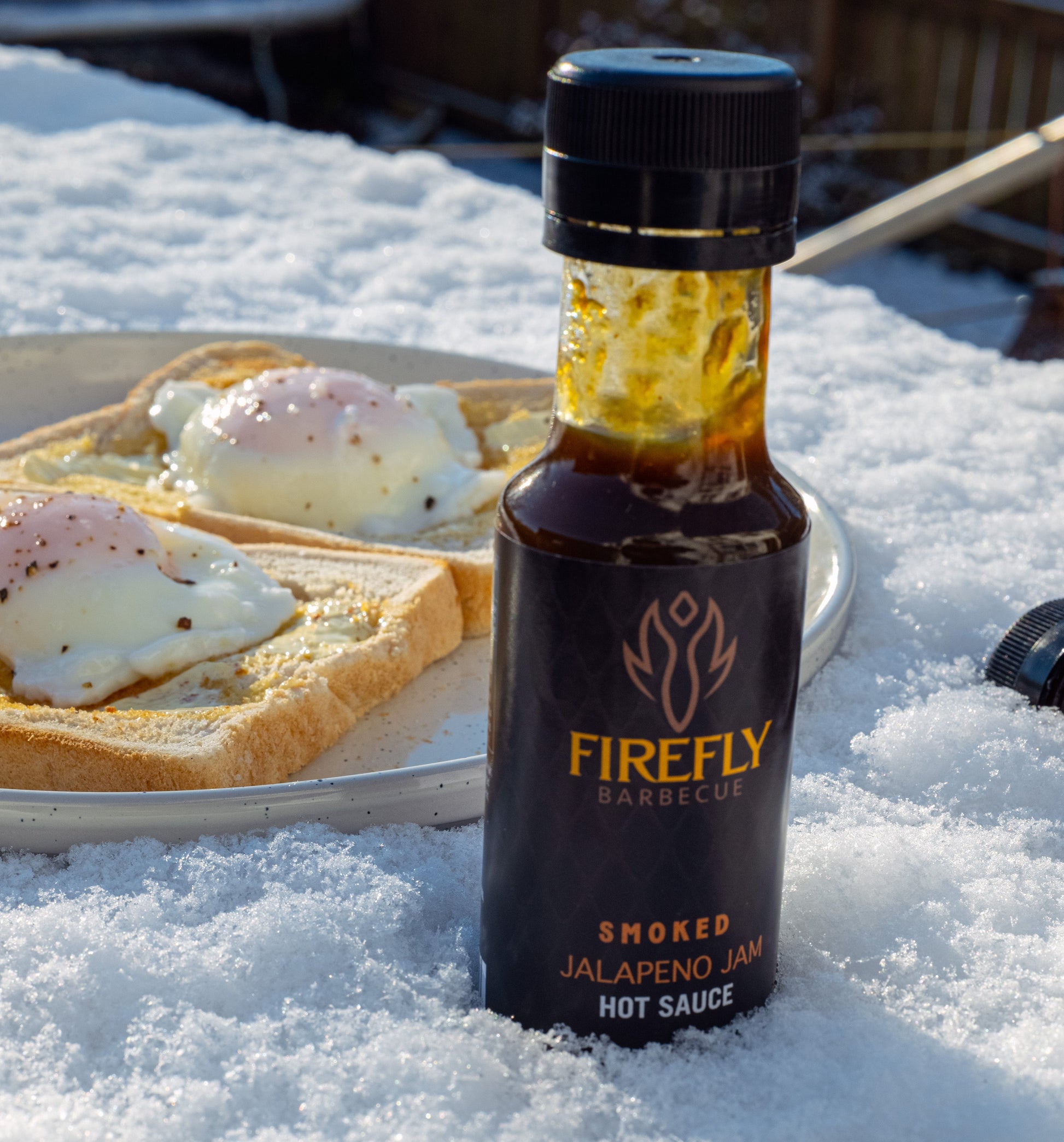 Spicy smoked jalapeño jam in a jar, a flavorful hot sauce by FireFly Barbecue with smoky green peppers and vibrant color.