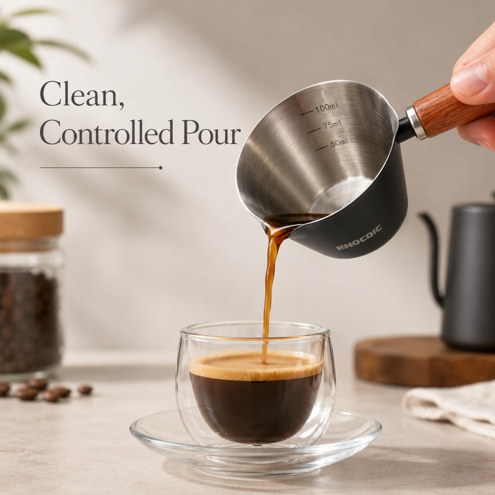 KNOCDIC® 100ml espresso measuring cup pouring liquid, made of clear glass with measurement markings for accurate coffee brewing.