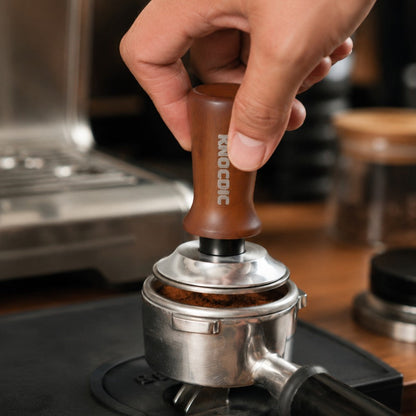 KNOCDIC® spring-loaded espresso tamper in use, showing its ergonomic handle and precision base for even coffee tamping.