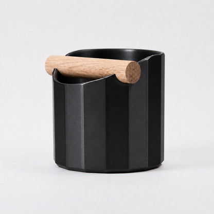 KNOCDIC® Facet Geometric Espresso Knock Box in metallic black with an oak knock bar for coffee preparation.