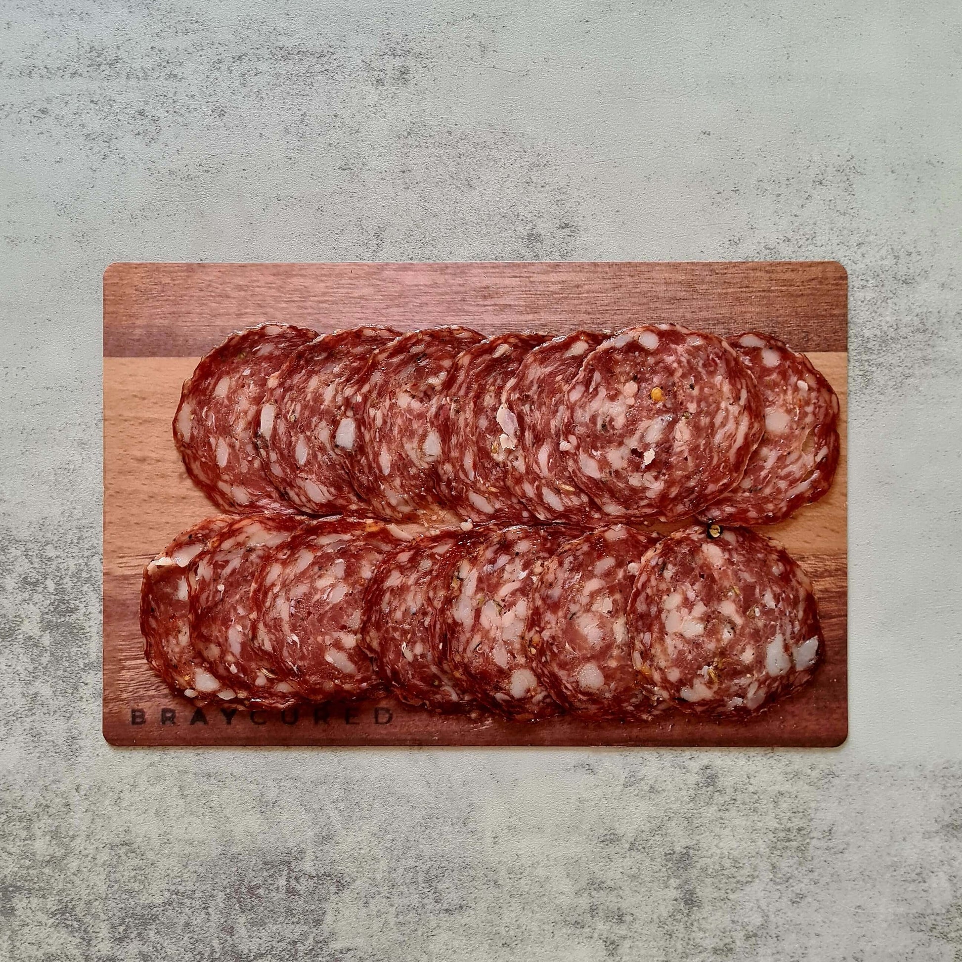 Sliced fennel salami from Bray Cured on a charcuterie board, showing thin slices of artisanal cured salami with fennel seeds.