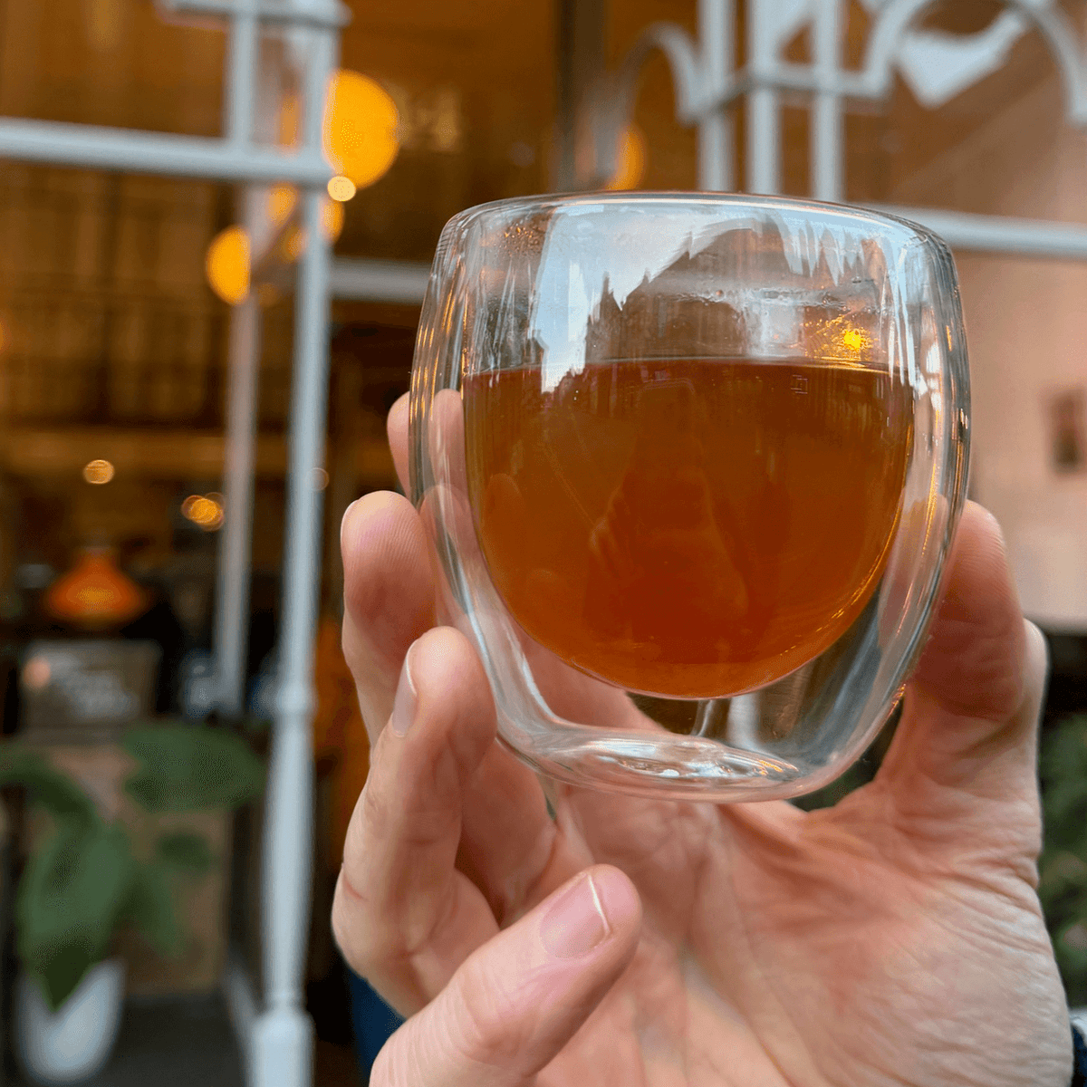 Brewed Formosa Oolong tea in a clear glass cup, showcasing its amber color and delicate floral aroma from Porter Hill Tea Company.