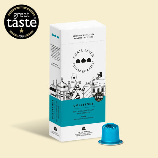 Goldstone Coffee Roasters Small Batch Roaster box in white and teal packaging, shown with a single blue coffee capsule on a light beige background. A black 'great taste 2026' award badge is displayed in the top-left corner.
