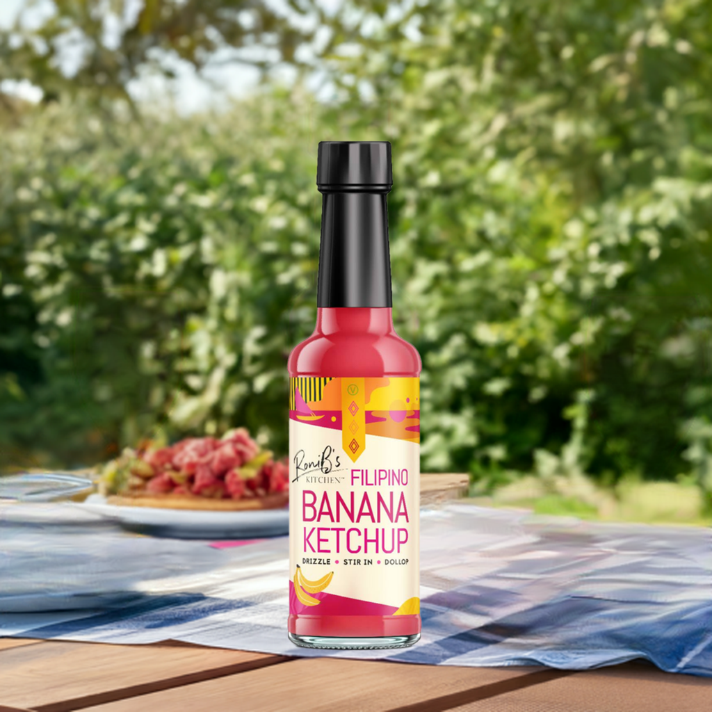 RoniBs Kitchen Filipino style banana ketchup bottle with bright label, showcasing the sweet and tangy condiment on a wooden surface.