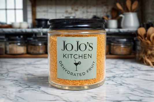 Bright orange grapefruit powder in a clear jar, showcasing the vibrant, finely ground citrus powder from JoJo’s Kitchen.