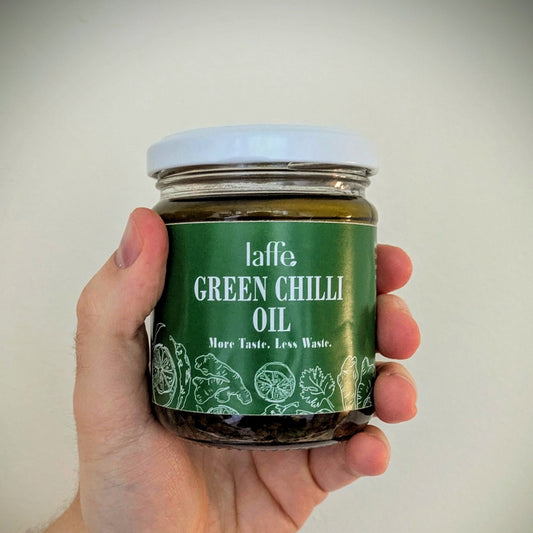 Hand holding a jar of Laffe Green Chilli Oil against a plain background