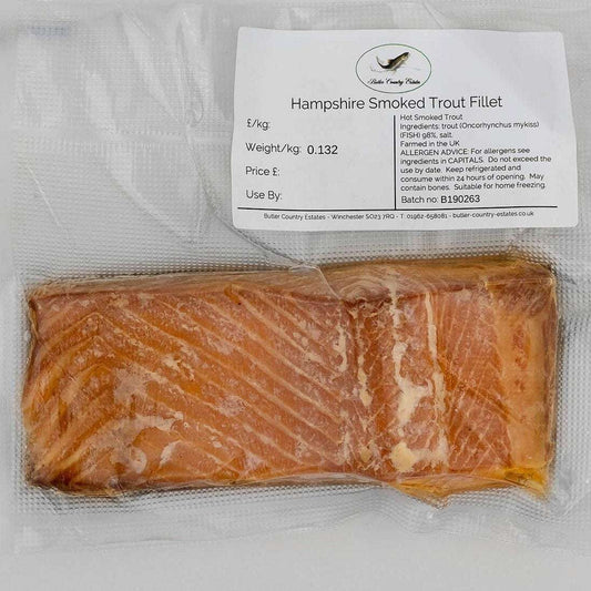 Smoked trout fillets from Hampshire by Butler Country Estates, neatly arranged on a platter with fresh herbs and lemon slices.