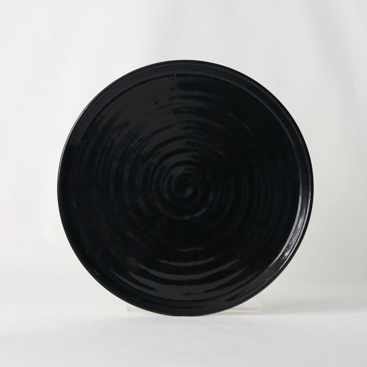 Handmade jet black ceramic side plate by Katie L Thompson Designs, showcasing elegant, minimalist design and smooth finish.