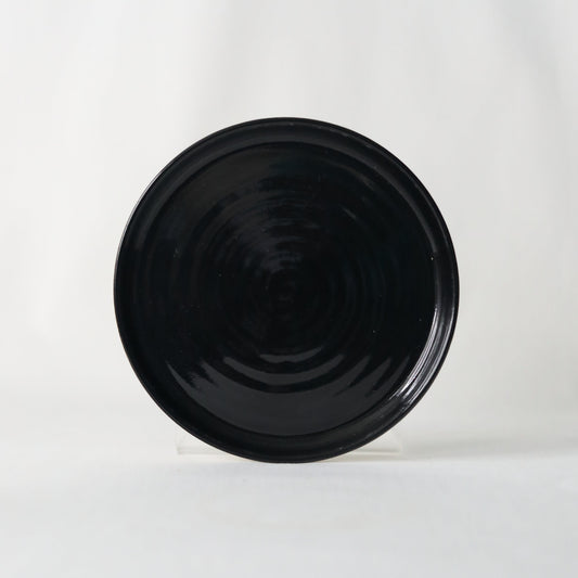Handmade jet black ceramic cake plate by Katie L Thompson Designs, featuring a sleek classic design for serving desserts.