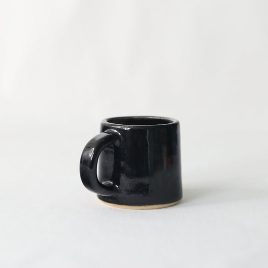 Handmade black ceramic espresso mug by Katie L Thompson Designs, featuring a sleek jet black finish and classic shape.