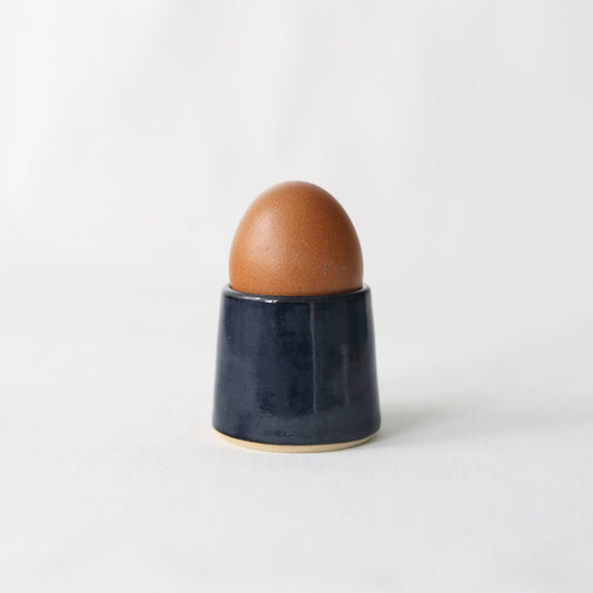 Handmade black ceramic egg cup from Katie L Thompson Designs, classic jet black style for serving soft-boiled eggs.