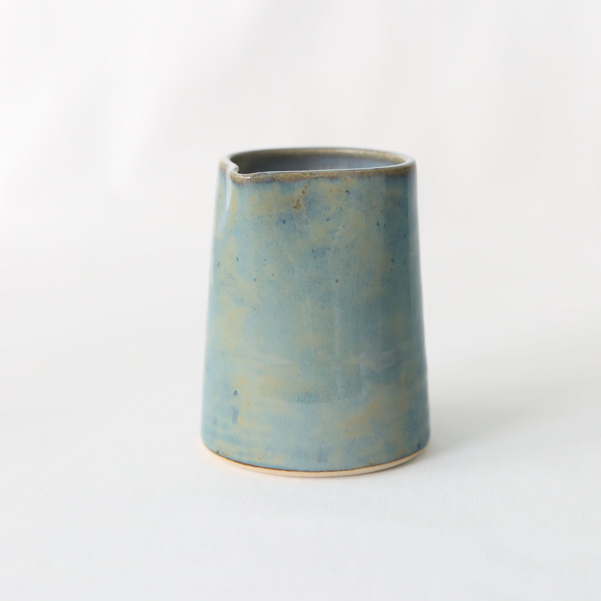 Seafoam blue ceramic small jug by Katie L Thompson Designs, handcrafted with a smooth, rounded shape and glossy finish.