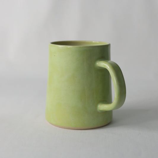 Handmade spring green ceramic pint mug by Katie L Thompson Designs, featuring a classic design and smooth finish.