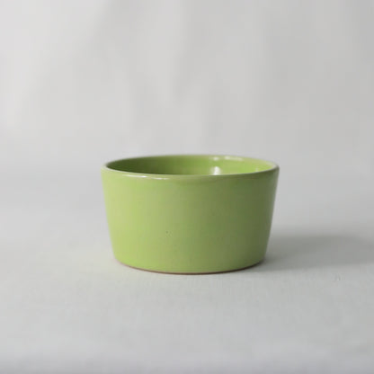 Handmade spring green ceramic side bowl by Katie L Thompson Designs, showcasing its vibrant color and decorative shape.