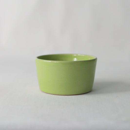 Handmade spring green ceramic side bowl by Katie L Thompson Designs, showcasing its vibrant color and decorative shape.