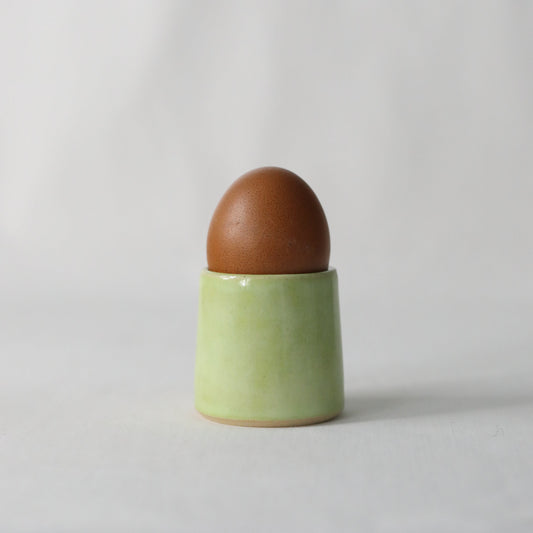 Handmade spring green ceramic egg cup by Katie L Thompson Designs, featuring a classic design for serving eggs.