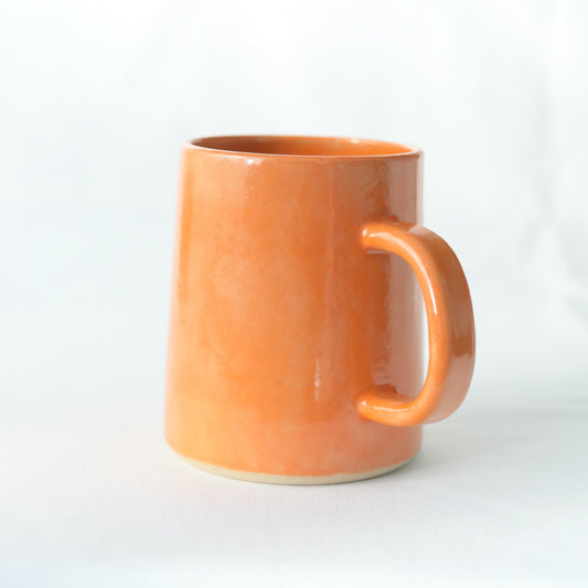 Handmade ceramic pint mug with a vibrant mandarin orange design by Katie L Thompson Designs.