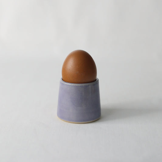 Handmade purple ceramic egg cup from Katie L Thompson Designs, classic egg holder with amethyst-inspired color and smooth finish.