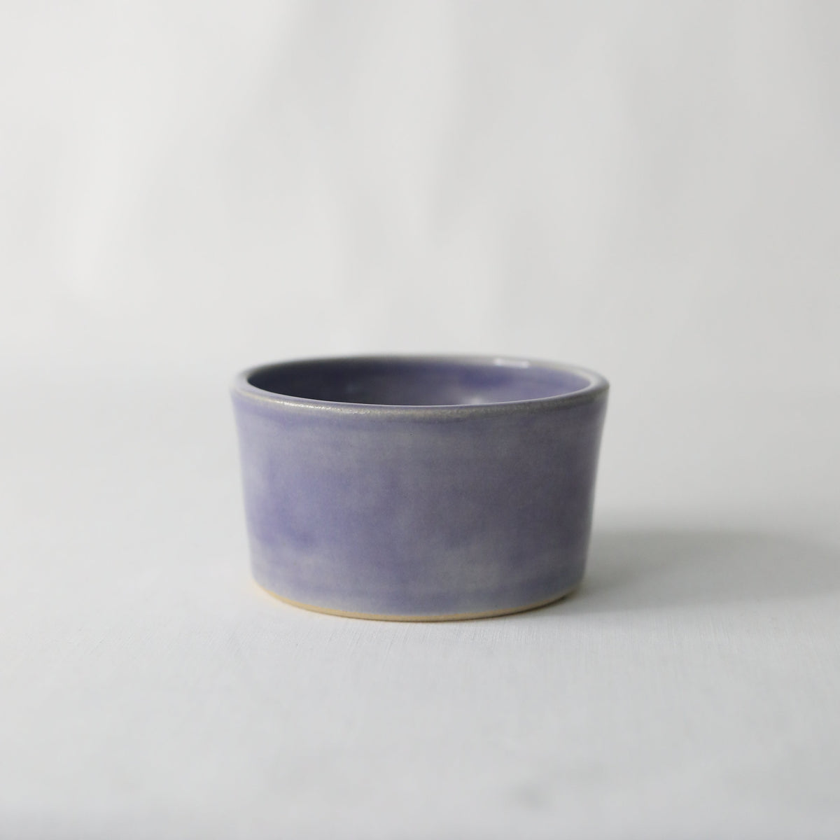Handmade amethyst purple ceramic side bowl by Katie L Thompson Designs, showcasing a smooth, rounded design perfect for serving.