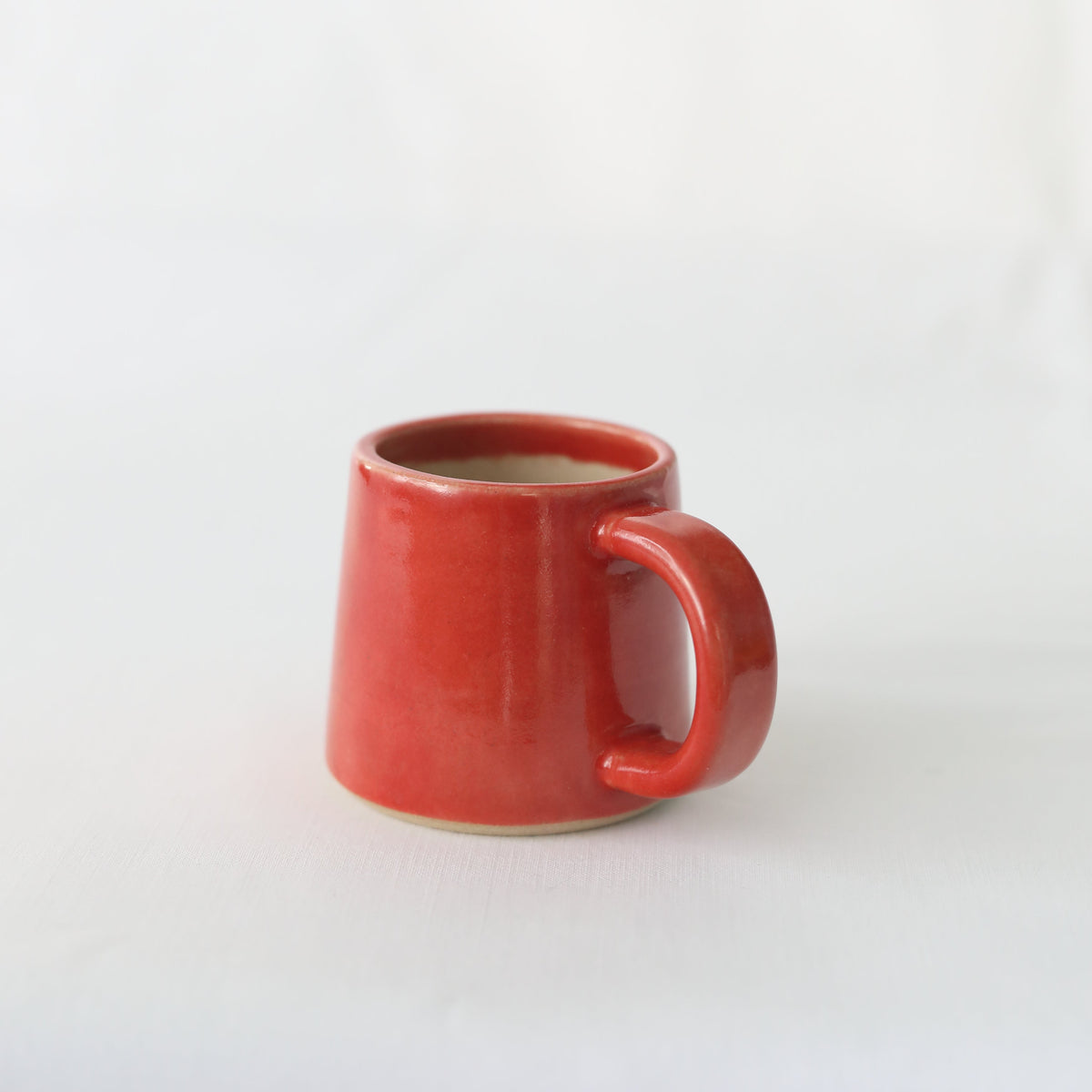 Handmade cherry red ceramic espresso mug by Katie L Thompson Designs, with a smooth, classic shape and glossy finish.