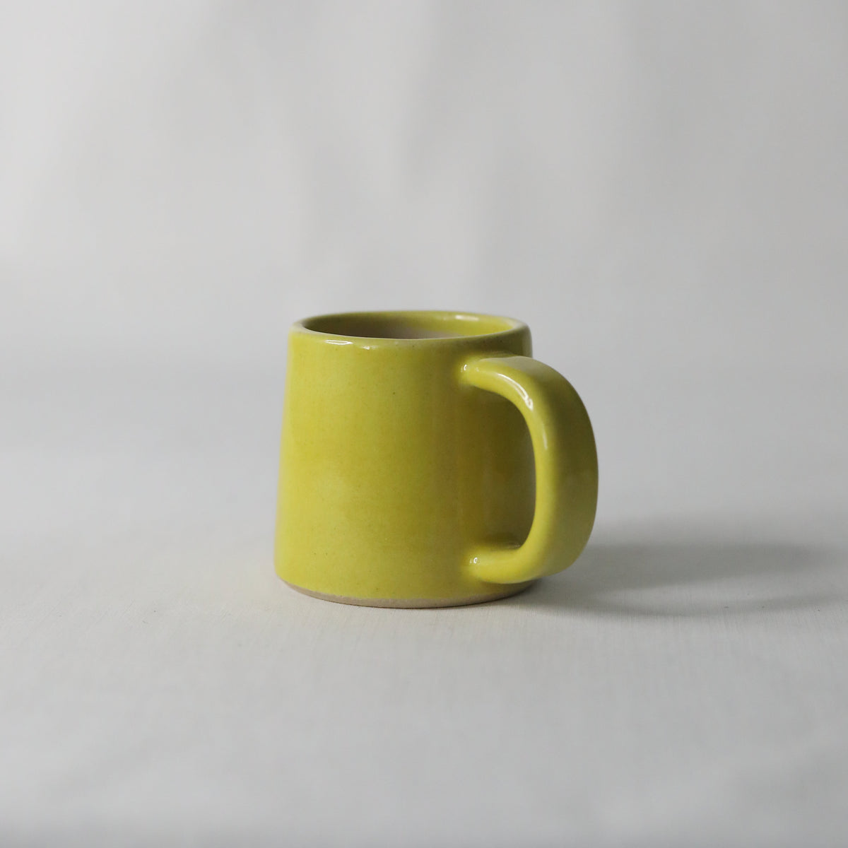 Sun yellow ceramic espresso mug by Katie L Thompson Designs, handmade with a classic shape and vibrant yellow glaze.