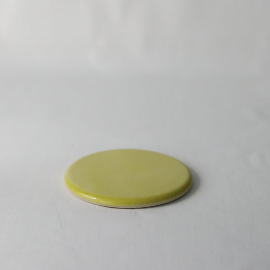 Sun yellow ceramic coaster with handmade design by Katie L Thompson Designs, featuring a vibrant, glossy finish and decorative pattern.
