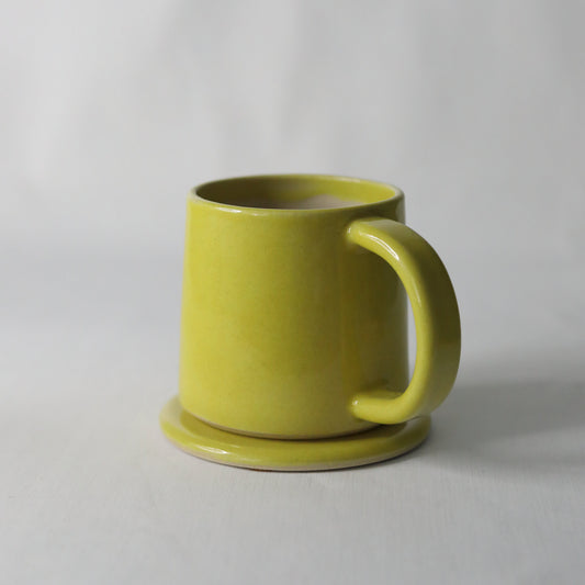 Sun yellow ceramic coaster featuring a classic design by Katie L Thompson Designs, perfect for protecting surfaces with style.