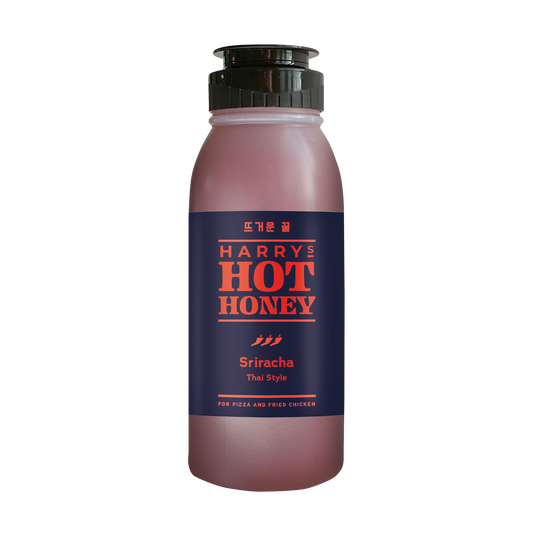 Harry's Hot Honey Sriracha hot honey in a clear glass bottle with a red and yellow label, showcasing the spicy sweet condiment.