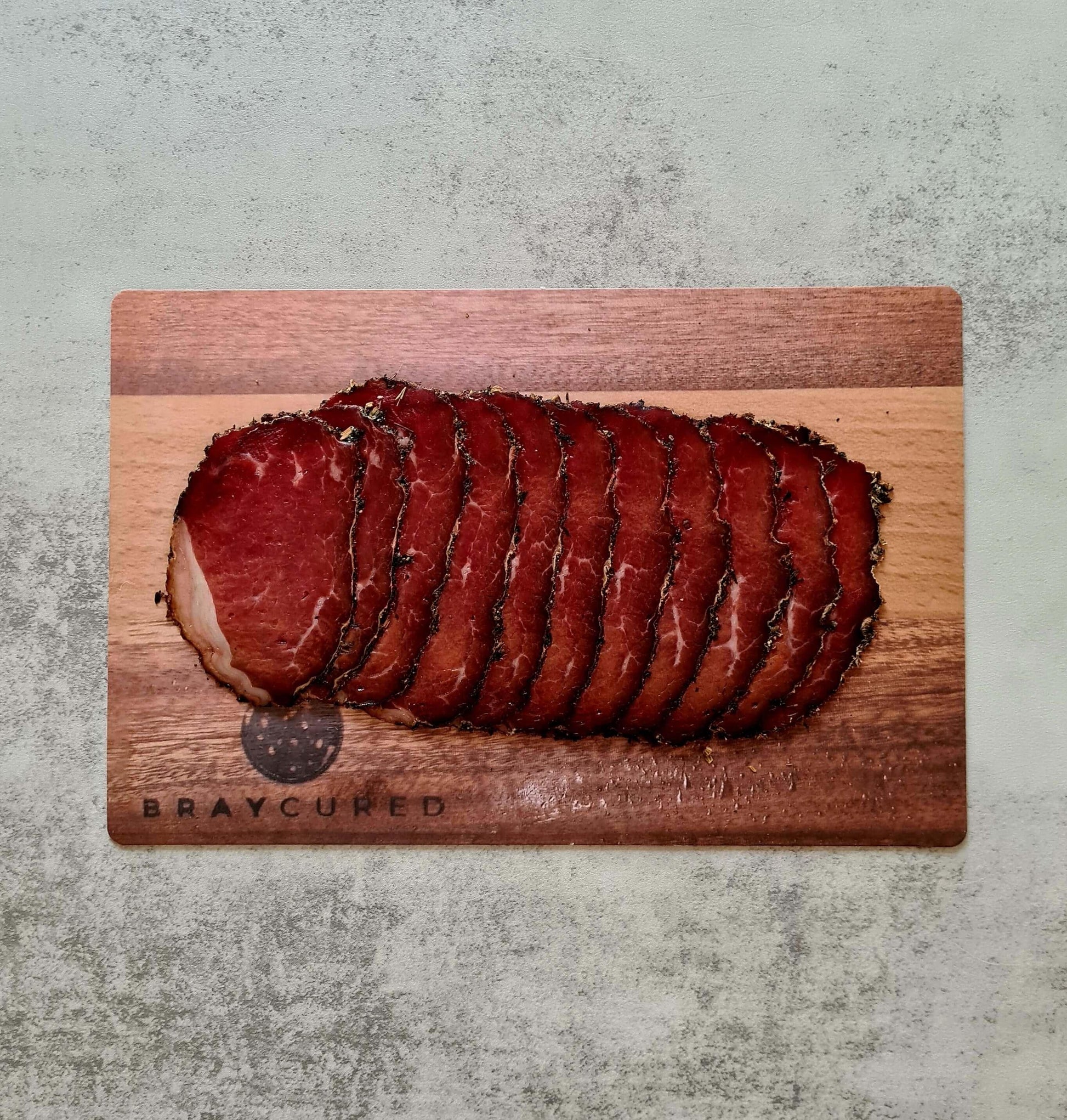 Bray Cured Bresaola trio with sliced cured ham and British red wine in a charcuterie hamper display.