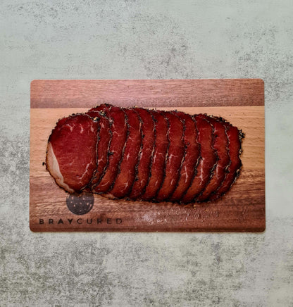 Bray Cured Bresaola trio with sliced cured ham and British red wine in a charcuterie hamper display.