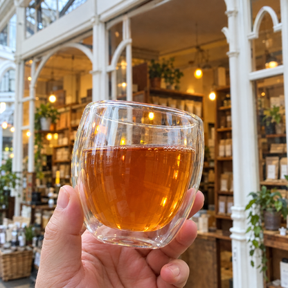Brewed Porter Hill Tea Company Hojicha green tea in a clear glass cup, showing its rich amber color and steaming hot liquid.