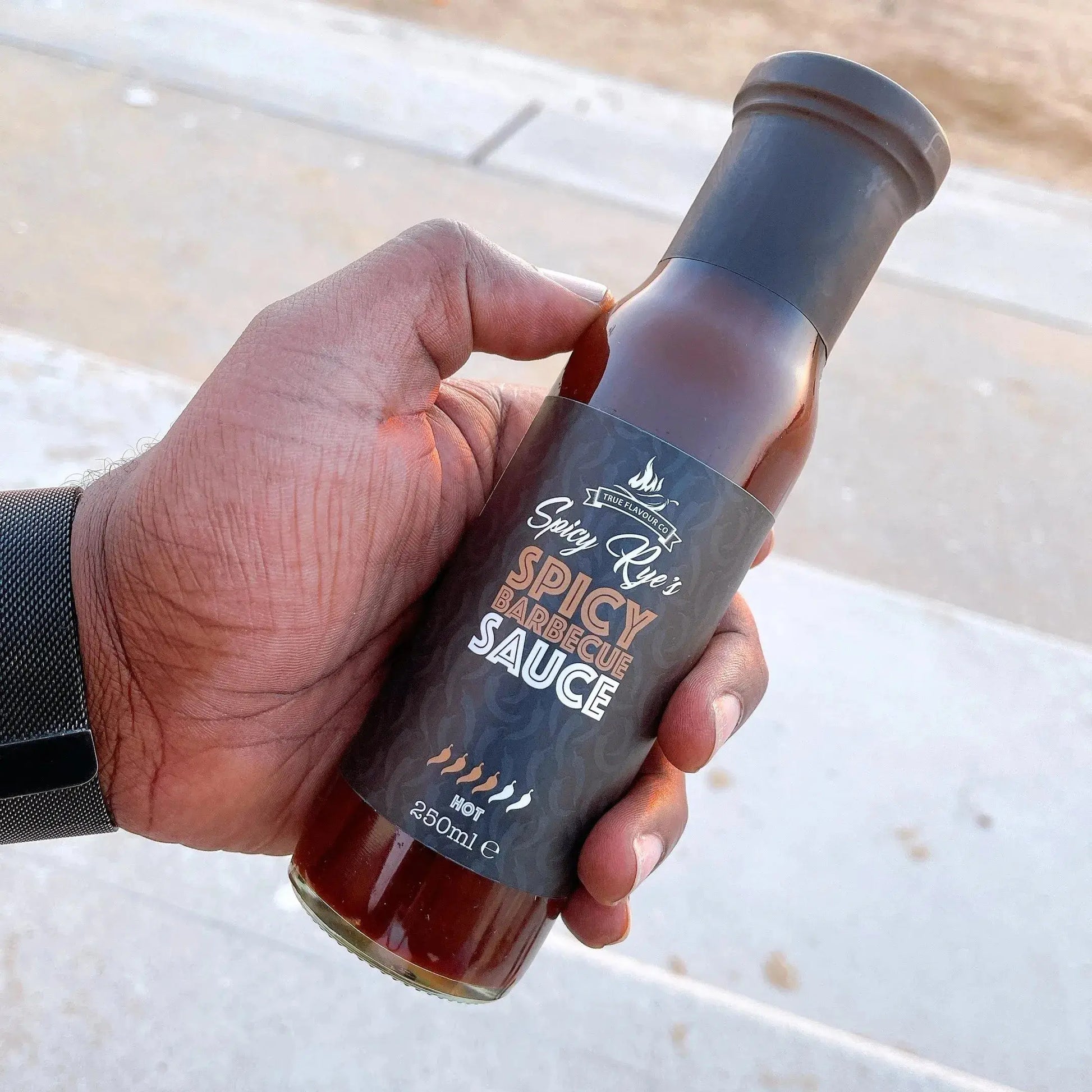 Spicy Ryes hot BBQ sauce in a glass jar, showcasing a rich, spicy red sauce perfect for grilling and flavoring dishes.