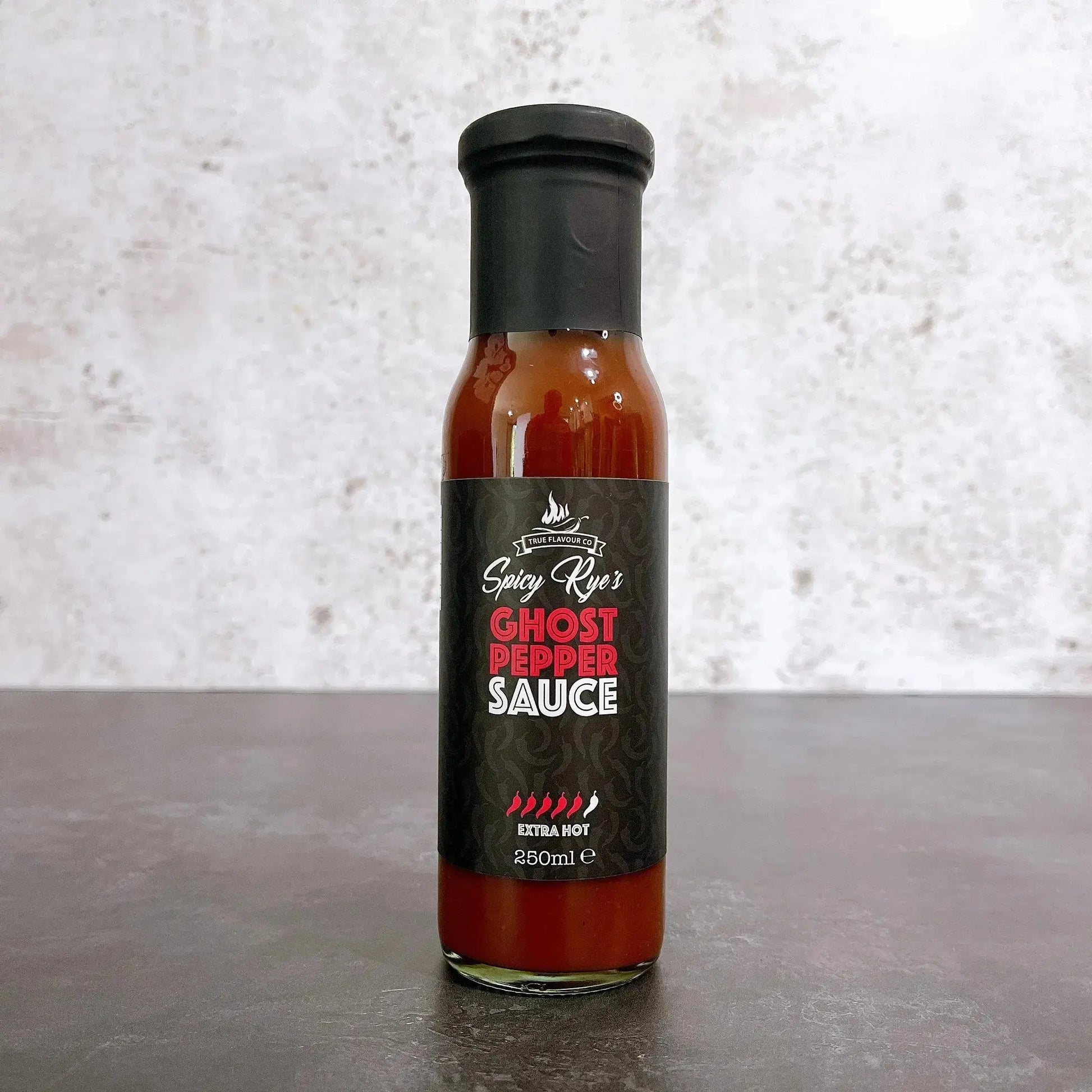 Spicy Ryes Ghost Pepper Hot Sauce bottle with fiery red sauce and label, showcasing intense chili peppers and branding.