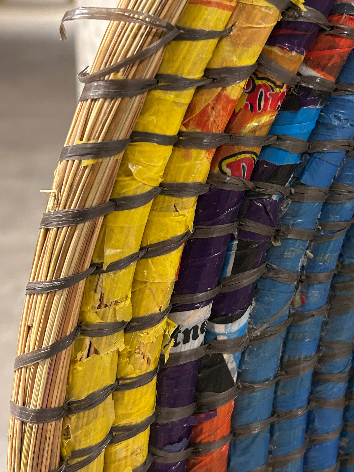 Zambian Botanical Boys wall basket made of woven natural fibers, featuring a round shape and intricate pattern for wall decor.