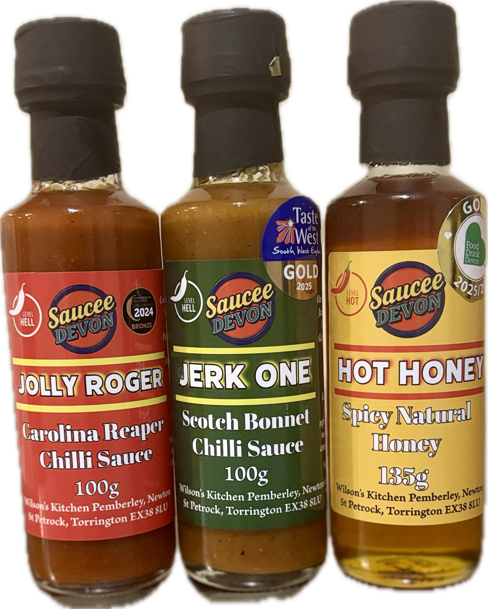 Assorted artisan chili sauces from Wilson’s Kitchen, featuring three vibrant hot sauce bottles with colorful labels.