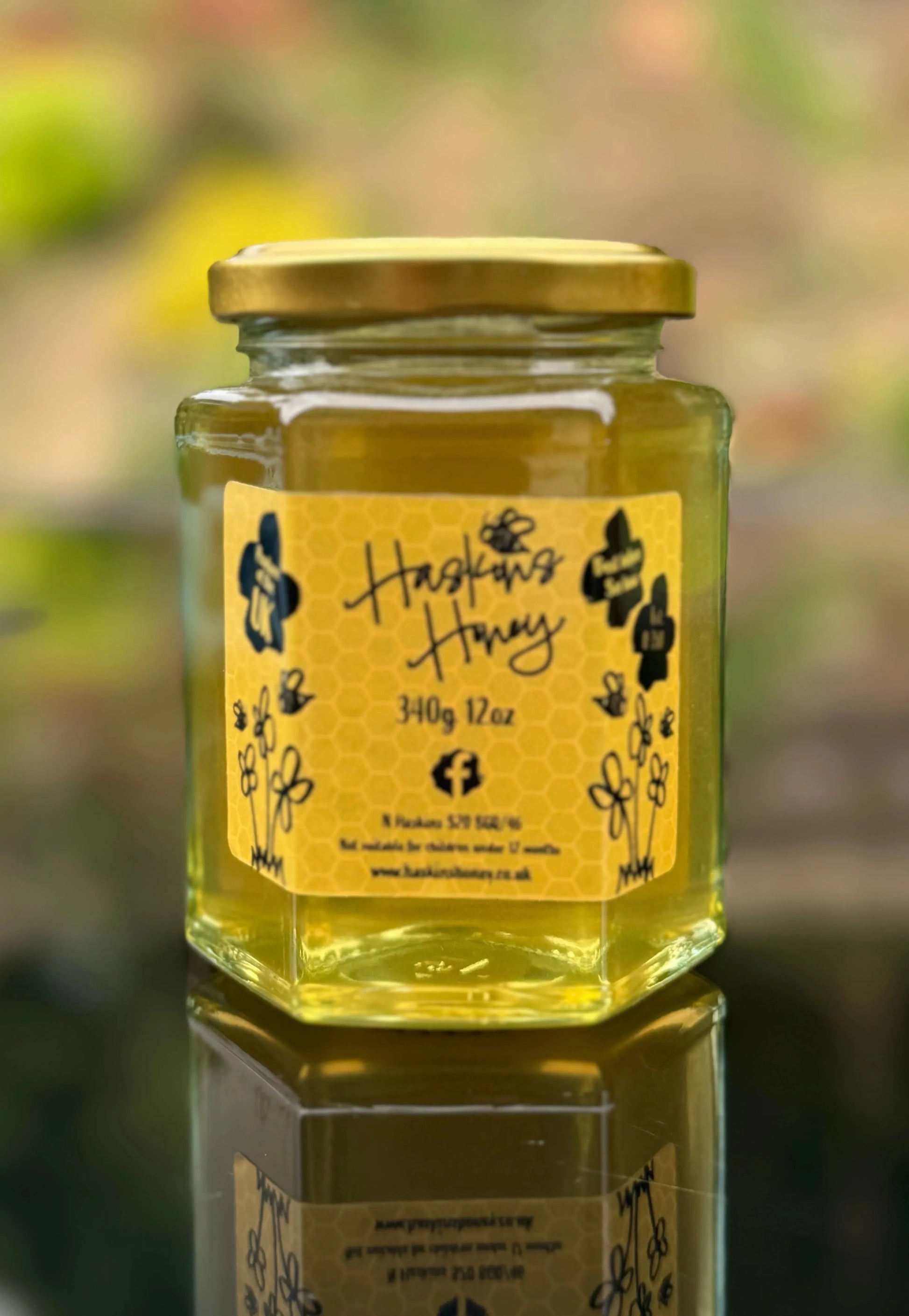 Wildflower honey jar from Haskins Honey with a golden honey surface and wildflower logo on the label.