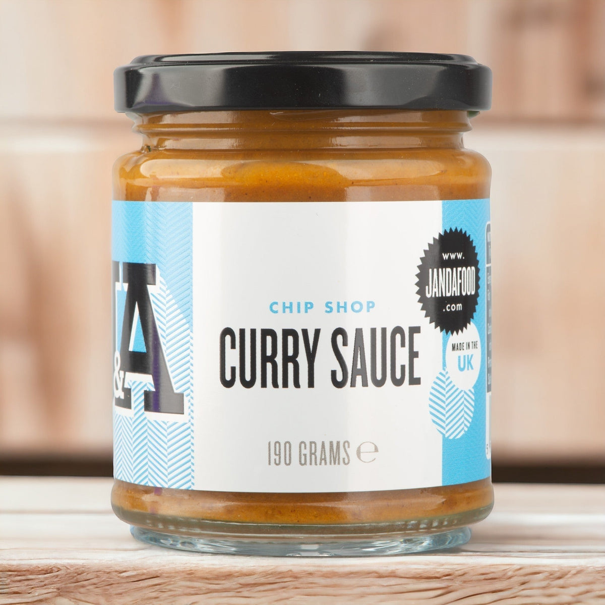 Janda Food Chip Shop Curry Sauce in a glass jar with a black lid, featuring a blue and white label.
