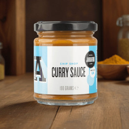 Janda Food Chip Shop Curry Sauce in a glass jar with a white label on a wooden table