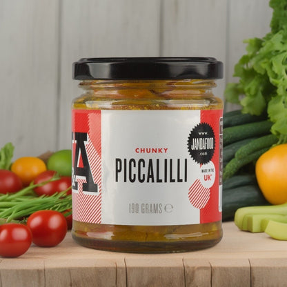 Jar of Janda Food Chunky Piccalilli relish with chunks of vegetables in a tangy, yellow mustard-based sauce.