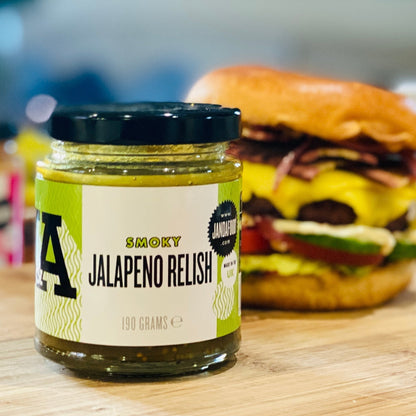 Janda Smoky Jalapeno Relish in a glass jar with a spoon, showcasing vibrant green jalapenos and smoky seasoning