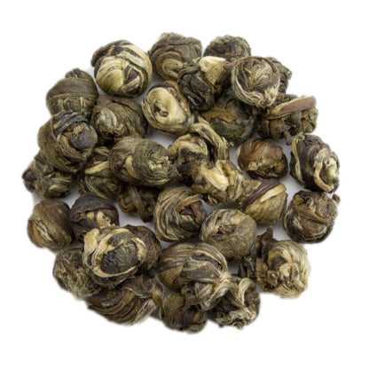 Fresh jasmine pearl green tea leaves from PekoeTea Edinburgh, showcasing tightly rolled green tea pearls with jasmine blossoms.