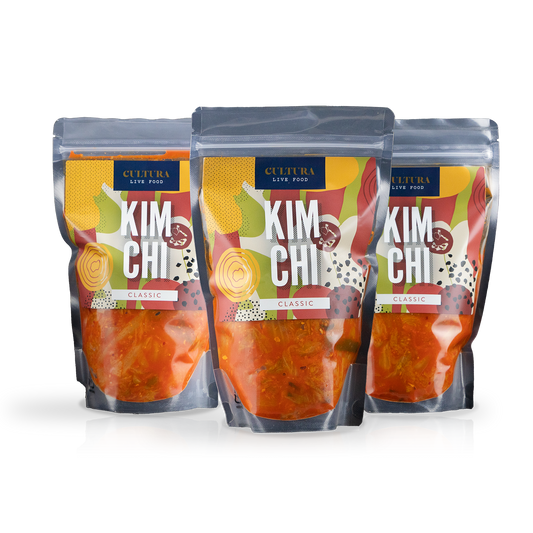 Three jars of Cultura Live Food Kimchi Bundle with vibrant vegetables and spicy fermented cabbage in glass containers.