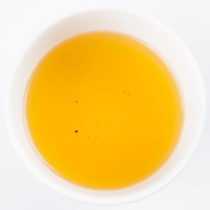 Golden brewed Kinnettles Scottish Grown Tea from PekoeTea Edinburgh in a clear cup, showcasing vibrant tea liquor.