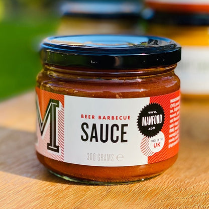 Bottle of Manfood Beer Barbecue Sauce with label featuring beer glass and smoky barbecue imagery.