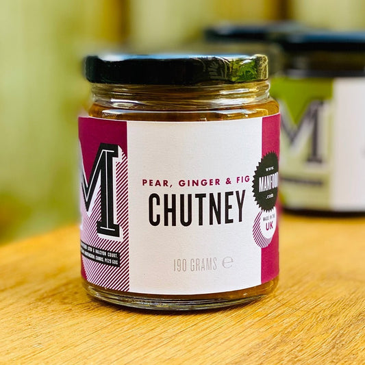 Manfood Pear, Apple, Fig, and Plum Chutney jar with fresh fruits and ginger, showcasing the flavorful chutney inside.