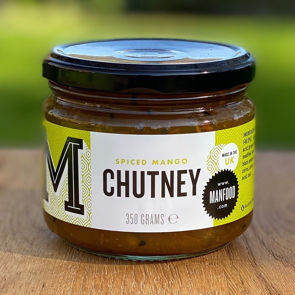 Jar of Manfood Spiced Mango Chutney with visible orange mango chunks and spices, served in a glass jar.