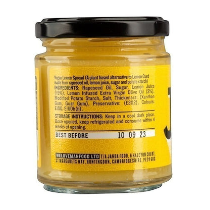 Jar of Manfood vegan lemon curd with a label, showcasing creamy lemon spread in a glass jar on a neutral background.