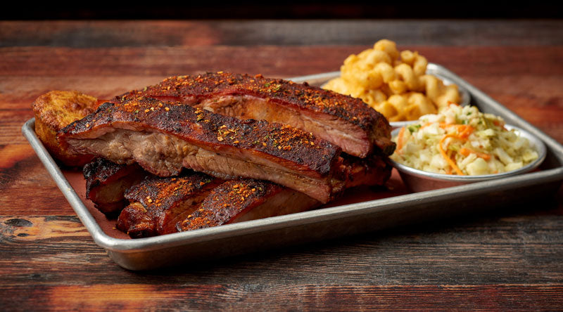 Memphis Dry Savoury BBQ Rub by FireFly Barbecue on pork spare ribs, showcasing seasoned, glazed ribs ready for grilling.