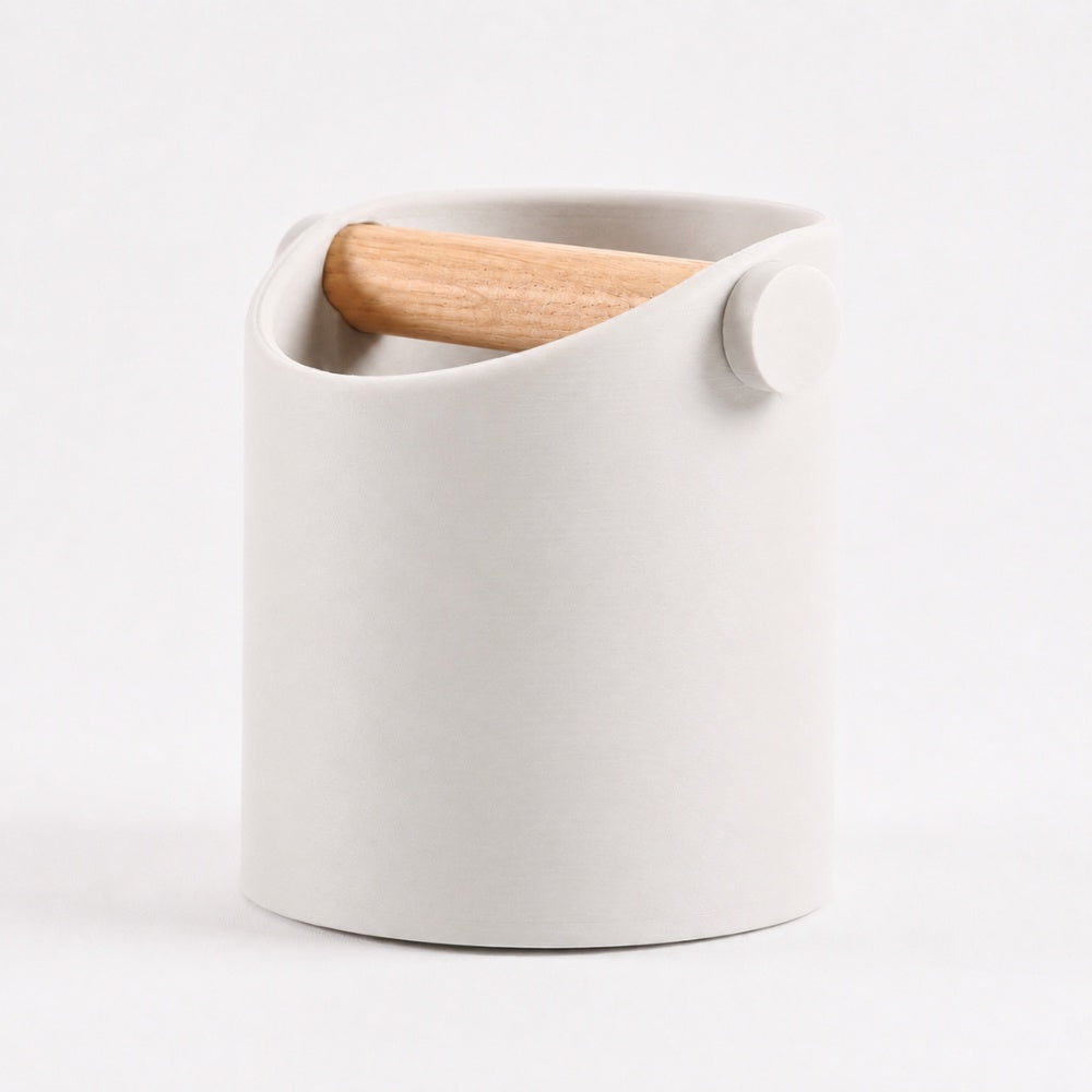 Minimalist coffee knock box with off-white body and real oak wood bar, branded KNOCDIC®, for espresso machine cleaning.