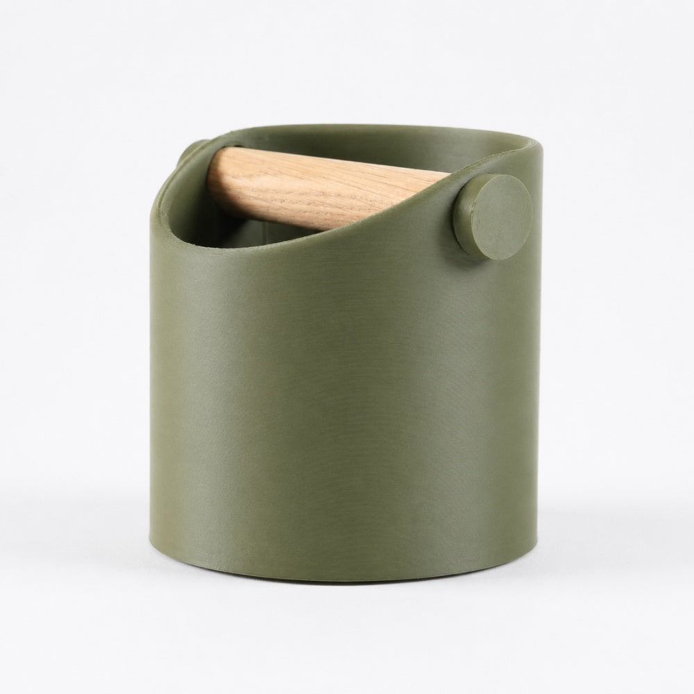 Minimalist KNOCDIC® coffee knock box with olive green finish and real oak wood bar for espresso puck disposal.